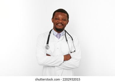 Smiling Black Bearded Doctor Man Crossed Arms In White Robe With Stethoscope Isolated On White Background. Adult Black African American Physician Therapist Portrait, Confident Candid Male Emotion