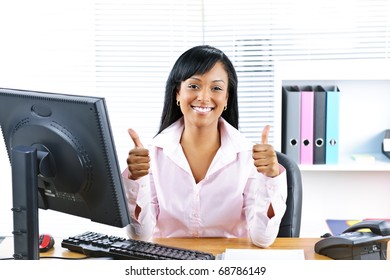 Smiling Black Business Woman Giving Thumbs Up Gesture At Desk In Office