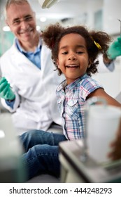 Smiling Black Child In Dental Clinic After Repairing Tooth
