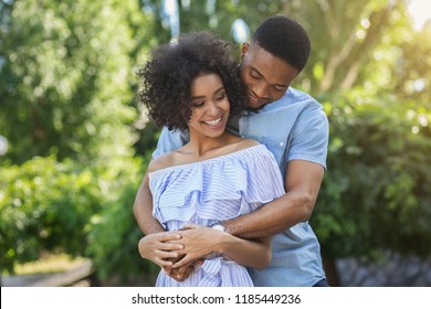 Smiling Black Couple Embracing In Park On Sunny Day