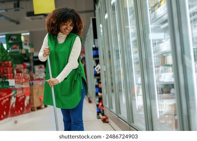 A smiling black female employee in the market is cleaning so that the hygiene of the market is at a high level. - Powered by Shutterstock