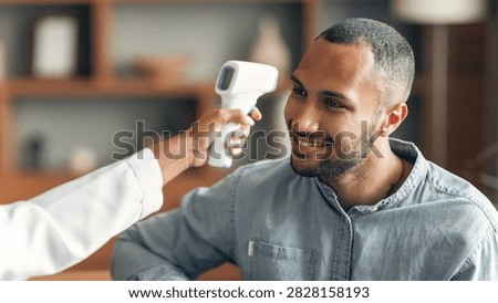 Smiling Black Man Getting Temperature Check With Infrared Thermometer At Clinic, Healthcare Concept