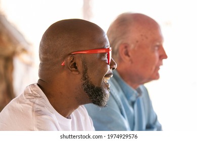 A Smiling Black Man Living With HIV Sitting Beside An Older Caucasian Man