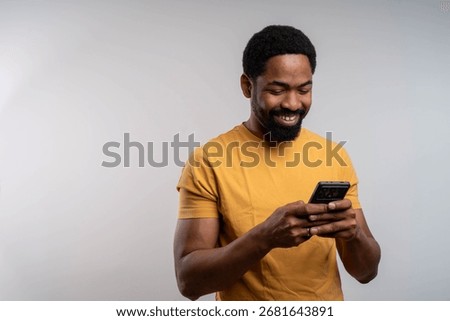 Smiling black man using mobile phone isolated on background with copy space modern technology digital communication concept
