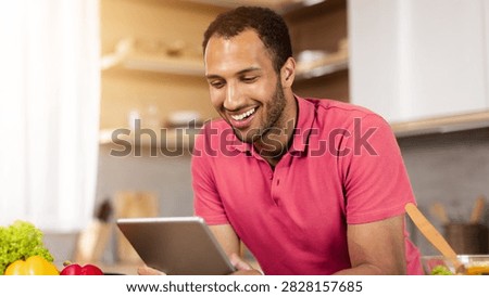 Smiling Black Man Using Tablet While Cooking In Modern Kitchen, Healthy Lifestyle Concept