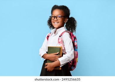 Smiling Black Schoolgirl Holding Books Ready For Back To School Standing In Studio On Yellow Background. School Education Concept - Powered by Shutterstock