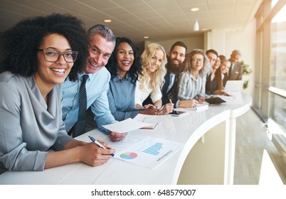 Smiling black and white coworkers looking at camera in the office. - Shutterstock ID 648579007