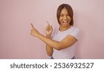 Smiling black woman points sideways against a pink background