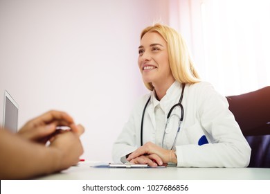 Smiling Blond Doctor Giving Good News. Doctor Reviewing Good Test Results To A Patient.