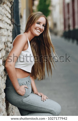 Similar – Happy young woman with moving hair in urban background