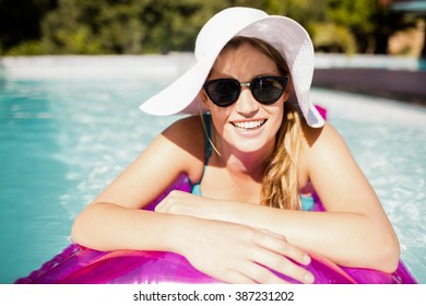 Smiling blonde on lilo in the pool