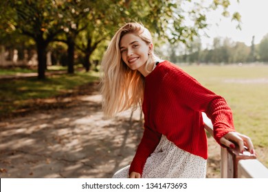 Smiling blonde woman laughing on the street cheerfully. Lovely young lady feeling happy in the autumn park. - Powered by Shutterstock