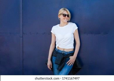 Smiling Blonde Woman With Sunglasses And White Tee Against Blue Metal Background In City Summer Day T Shirt Mock Up