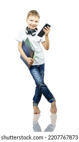 Smiling Boy With Books And Smartphone Stands On White Background. Schoolboy Barefoot, Isolated