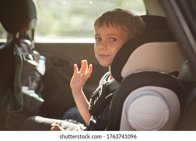 Smiling Boy In The Car Waving Goodbye