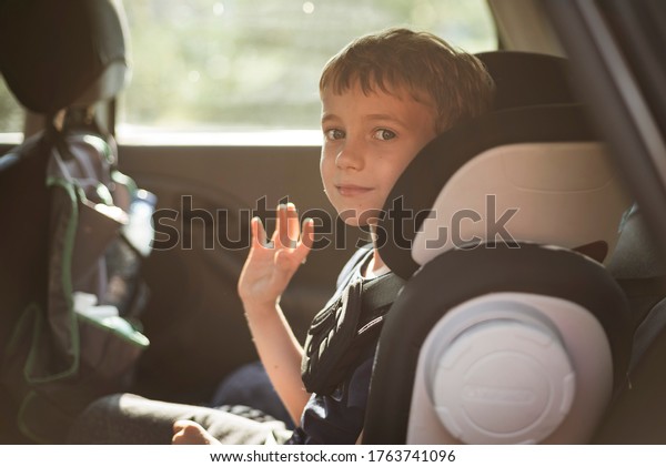 Smiling boy in the car
waving goodbye