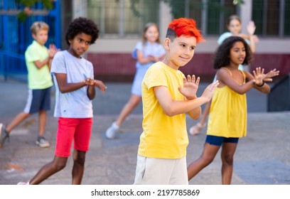 Smiling Boy With Dyed Hair Dancing With Team Outdoors And Having Fun.