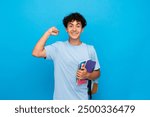 Smiling boy guy high school male pupil student teenager with backpack holding books copybooks winning gesture celebrating having success standing isolated on blue background copy space