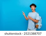 Smiling boy guy high school male pupil student teenager with dental braces backpack pointing index finger empty copy space advertisement isolated on blue background. Education back to school concept