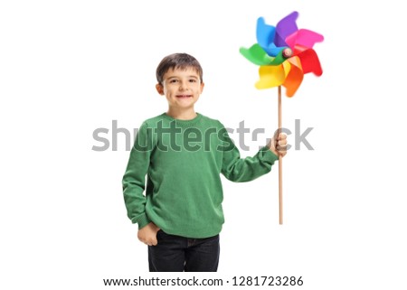 Smiling boy holding a colorful windmill toy isolated on white background