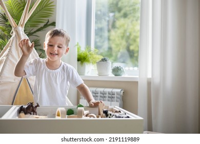 Smiling Boy Kid Playing Sensory Box Kinetic Sand Table With Montessori Wooden Materials And Farm Animals Closeup. Happy Baby Child Enjoy Childhood Early Development At Room With Wigwam Camping