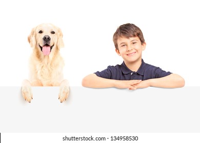 A smiling boy and Labrador retriever posing behind a blank panel