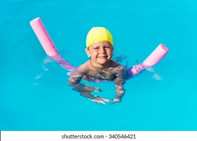 Smiling Boy Learns How To Swim With Pool Noodle