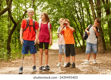 Smiling boy with prosthetic leg standing on footpath with friends at forest - Powered by Shutterstock