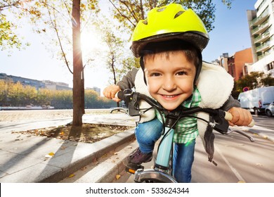 Smiling boy in safety helmet riding his bike