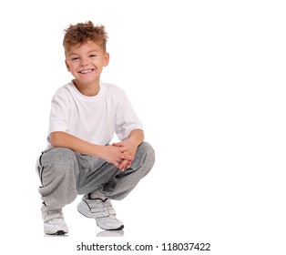 Smiling Boy Sitting On Floor Isolated On White Background