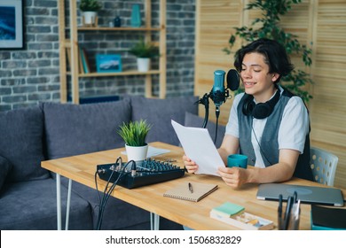 Smiling boy teenager is reading aloud in microphone recording podcast in modern studio creating content for online blog. People, youth and blogging concept. - Powered by Shutterstock