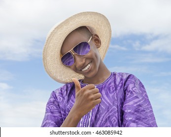 Smiling boy wearing a boater straw hat and a pair of sunglasses