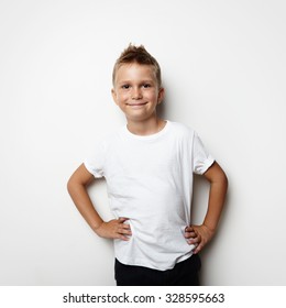 Smiling Boy Wearing White Tshirt And Shorts On The Blank Wall Background.