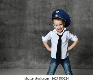 Smiling boy in white shirt, jeans, tie and police cap standing and playing in policeman over grey background. Trendy children clothes and children games concept - Powered by Shutterstock