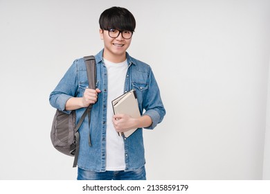 Smiling with braces young asian korean smart man student high schoolboy holding textbooks and notebooks, carrying a bag, going to university school college isolated in white background - Powered by Shutterstock