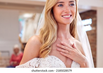 Smiling Bride In Bridal Store Trying On Wedding Dress