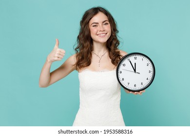 Smiling Bride Young Woman 20s Years Old In Beautiful White Wedding Dress Hold Clock Showing Thumb Up Isolated On Blue Turquoise Color Background Studio Portrait. Ceremony Celebration Party Concept