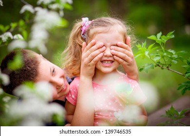 Smiling brother and sister playing in the garden