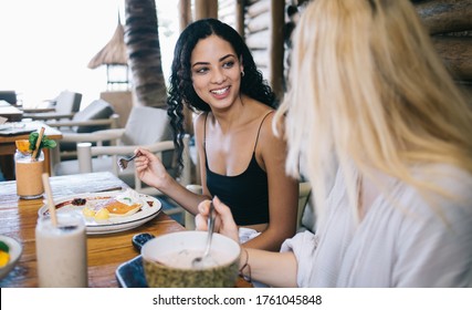 Smiling Brunette And Blonde Female Friends Having Positive Conversation During Lunch Break Enjoying Tasty Meal, Happy Women Discussing Plans While Eating Healthy Vegan Meal For Nutrition And Dieting