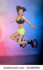 Smiling brunette girl with long hair  jumping in  kangoo jumps shoes