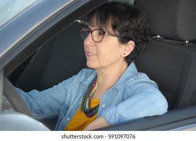 Smiling Brunette Mature Woman Driving Car