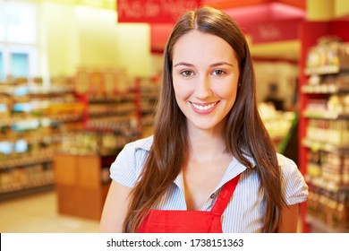 Smiling Brunette Saleswoman Is Standing In The Supermarket