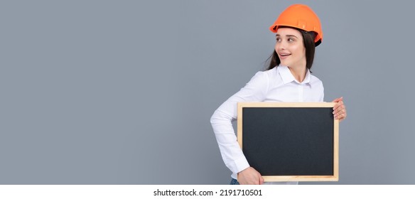 Smiling Business Builder Woman With Board. Woman Worker Builder Hold Sign Board Blank. Building Hardhat Helmet. Woman Isolated Face Portrait, Banner Header Poster With Mockup Copyspace.