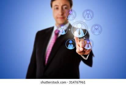 Smiling Business Consultant Is Contacting A Virtual Work Team By Touch. The Team Has A Male Team Leader And Three Female And Male Knowledge Workers. Metaphor For Remote Work Force In Cyber Space.