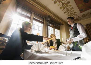 Smiling business couple ordering food at restaurant table - Powered by Shutterstock