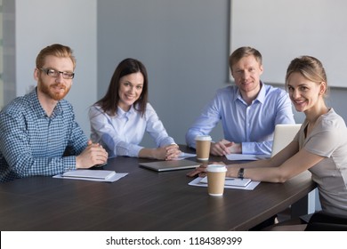 Smiling Business Group Of Office Workers, Executive Board Members Or Employees Looking At Camera Sitting At Conference Table, Happy Successful Project Team People Posing In Meeting Room, Portrait