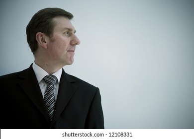 A Smiling Business Man Landscape Orientation With Copy Space To The Right. Profile Looking Out Of Frame