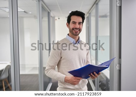 Smiling business man as a successful start-up founder with documents in the office
