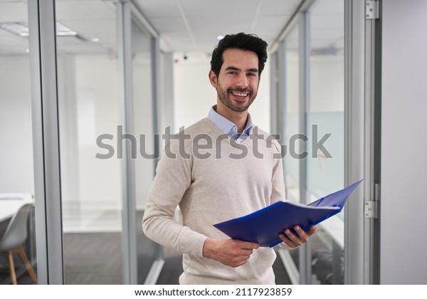 Smiling business man as a successful start-up\
founder with documents in the\
office