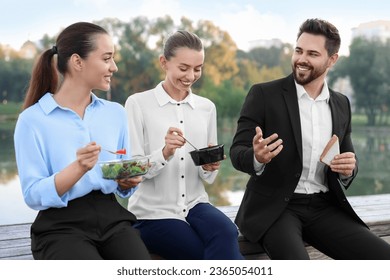 Smiling business man talking with his colleagues during lunch outdoors - Powered by Shutterstock